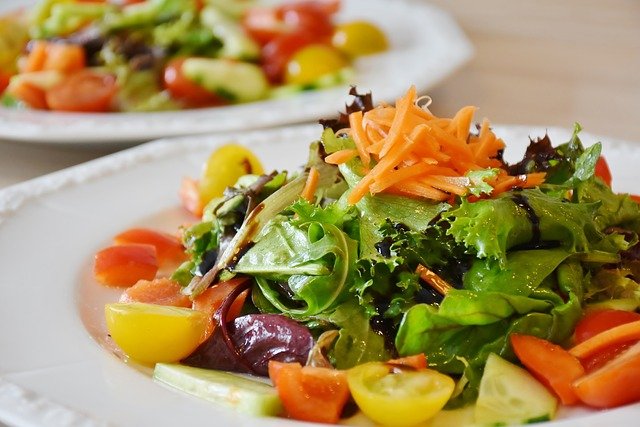 En sallad med färgglada grönsaker på en vit tallrik.