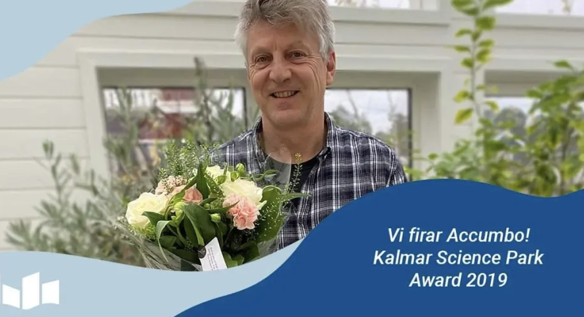 En man i 60-årsålder håller i en blombukett iklädd rutig skjorta.