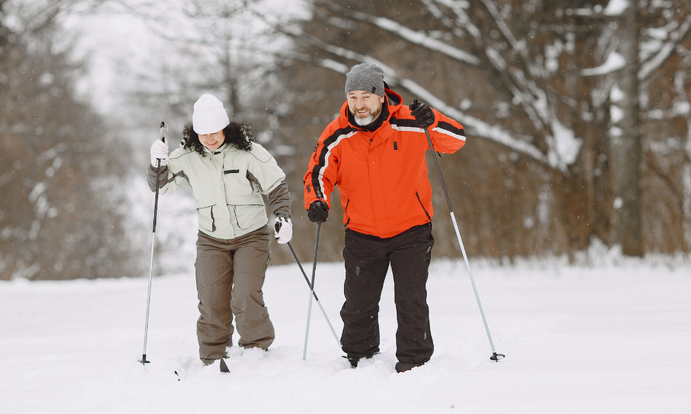 En man och en kvinna åker längdskidor i snön. 