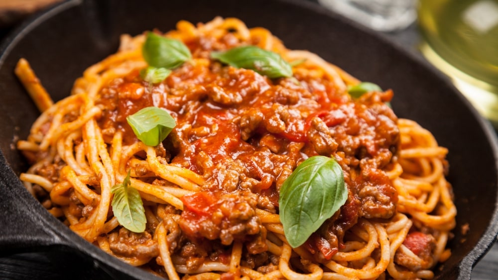 En skål med spaghetti och köttfärssås. 